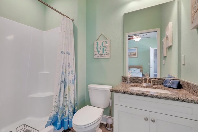 bathroom with vanity, toilet, walk in shower, and ceiling fan