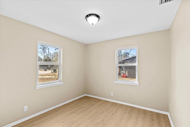 unfurnished room with light wood-type flooring and a healthy amount of sunlight