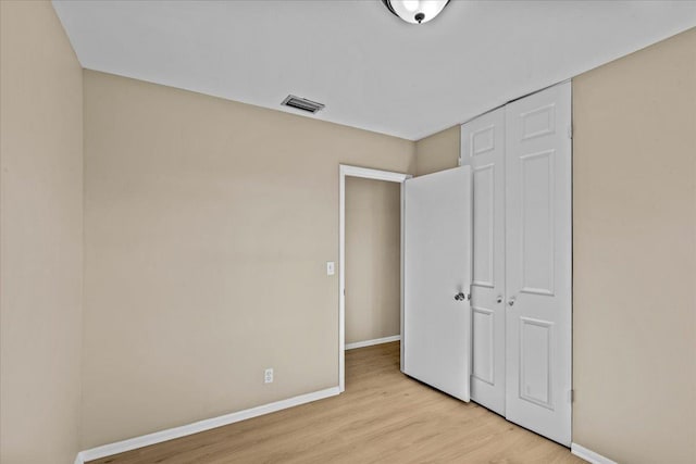 unfurnished bedroom with a closet and light hardwood / wood-style flooring