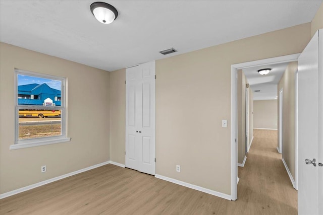 unfurnished bedroom featuring light hardwood / wood-style flooring and a closet