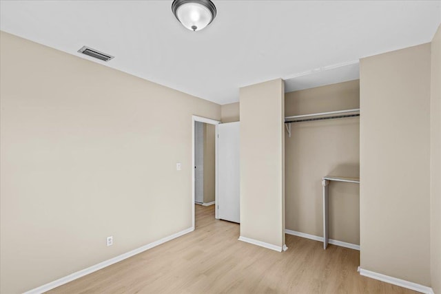 unfurnished bedroom with a closet and light wood-type flooring