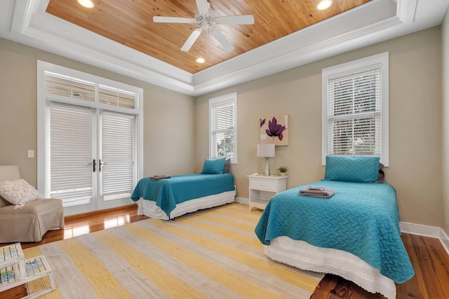 bedroom featuring access to outside, hardwood / wood-style flooring, a tray ceiling, and wood ceiling