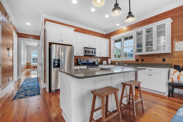 kitchen featuring white cabinetry, stainless steel appliances, and decorative light fixtures