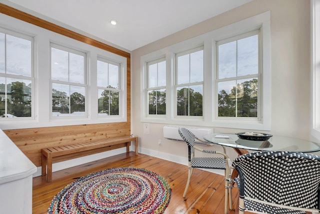 sunroom / solarium featuring a wall unit AC and a wealth of natural light