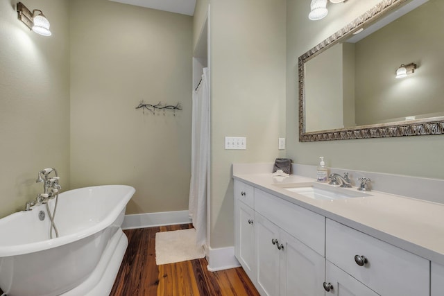 bathroom featuring hardwood / wood-style flooring, vanity, and a washtub