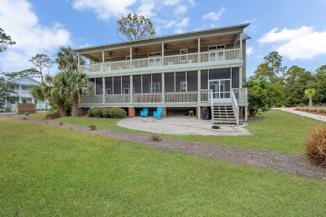 rear view of house with a lawn, a sunroom, and a balcony