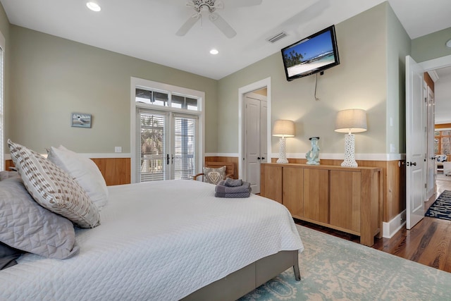 bedroom featuring french doors, access to exterior, wood walls, ceiling fan, and dark wood-type flooring