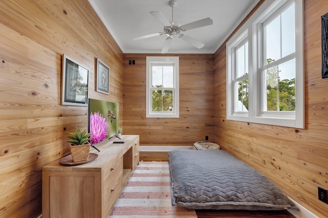 interior space featuring ceiling fan, light hardwood / wood-style flooring, and wooden walls