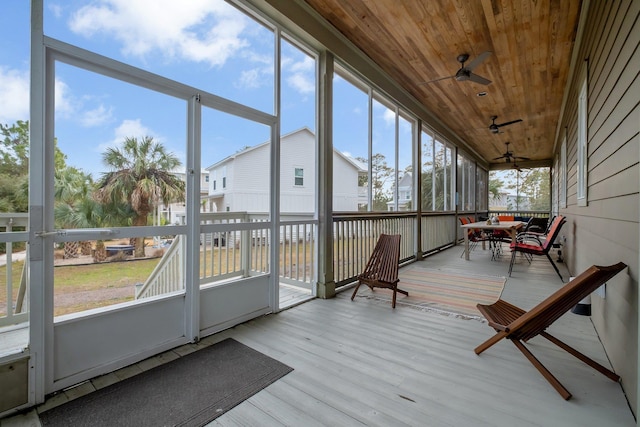 unfurnished sunroom featuring wooden ceiling and ceiling fan