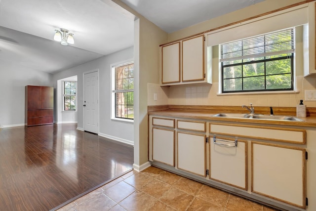 1541 San Luis Rd, Tallahassee, FL 32304 - kitchen featuring baseboards, vaulted ceiling, decorative backsplash, and a sink