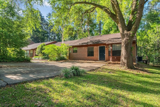 1541 San Luis Rd, Tallahassee, FL 32304 - single story home with central AC, driveway, brick siding, and a front yard
