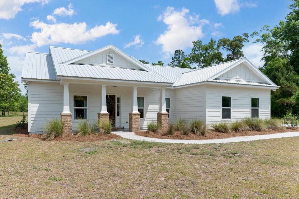 1740 Wakulla Arran Rd, Crawfordville, FL 32327 - view of front of home featuring board and batten siding, a porch, and metal roof