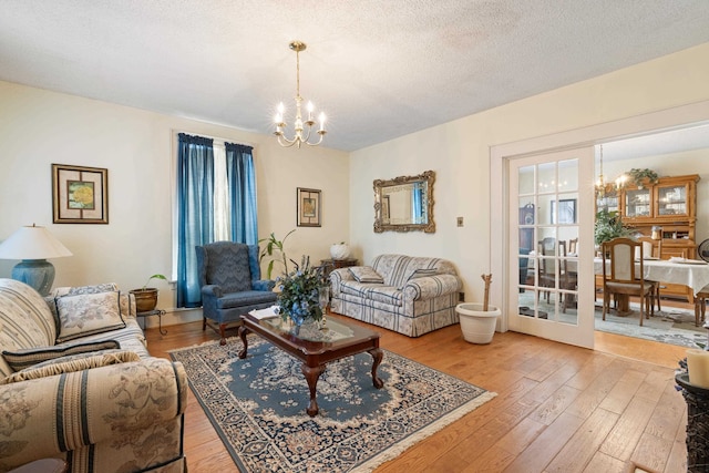 living room featuring a notable chandelier, a textured ceiling, and hardwood / wood-style flooring