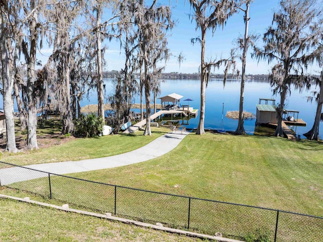 dock area featuring a yard, fence, and a water view