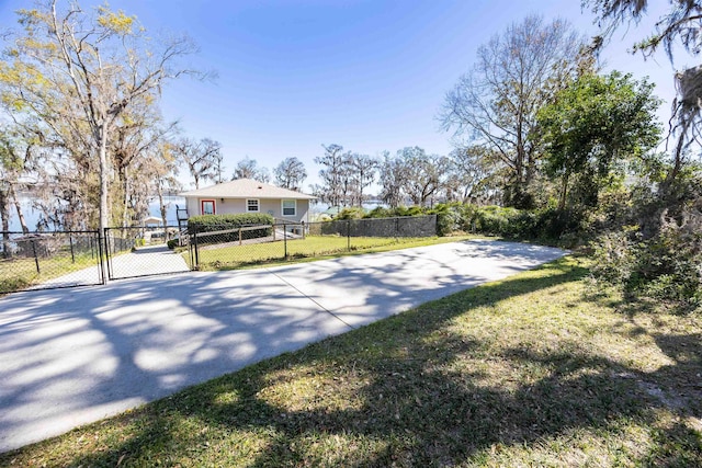 view of yard featuring driveway, fence, and a gate