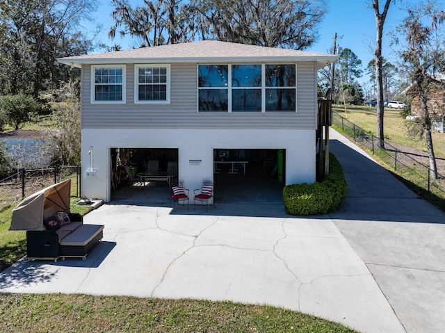 view of home's exterior featuring concrete driveway, an attached garage, and fence