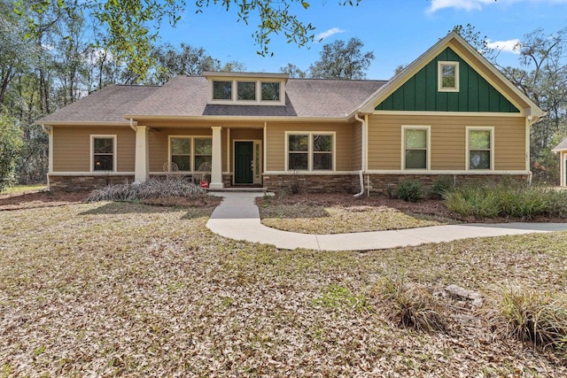 craftsman-style house with stone siding, board and batten siding, and roof with shingles