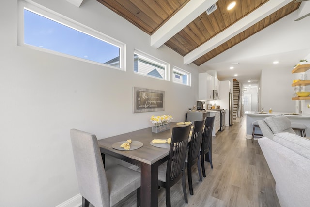 dining room with beamed ceiling, high vaulted ceiling, light hardwood / wood-style floors, and wooden ceiling