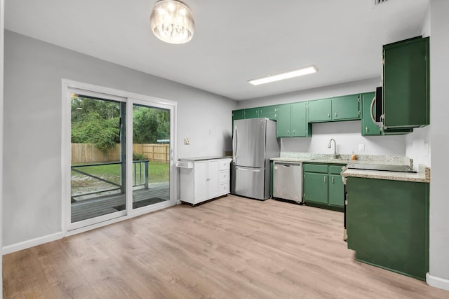 kitchen with light hardwood / wood-style floors, green cabinets, and stainless steel appliances