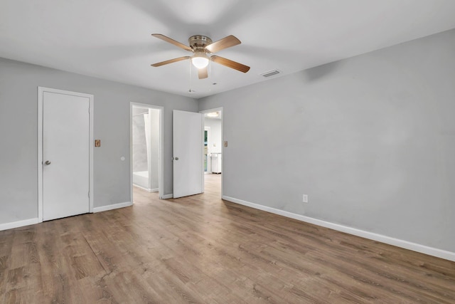 empty room with ceiling fan and light hardwood / wood-style flooring