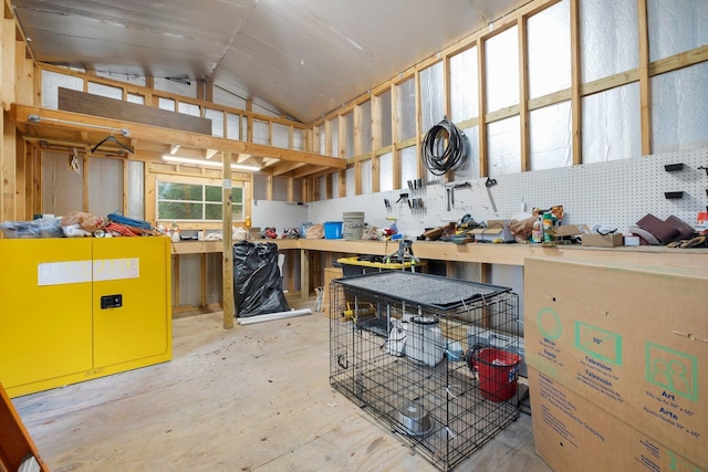 misc room with vaulted ceiling and a workshop area