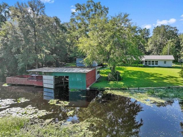 view of outbuilding with a lawn and a water view