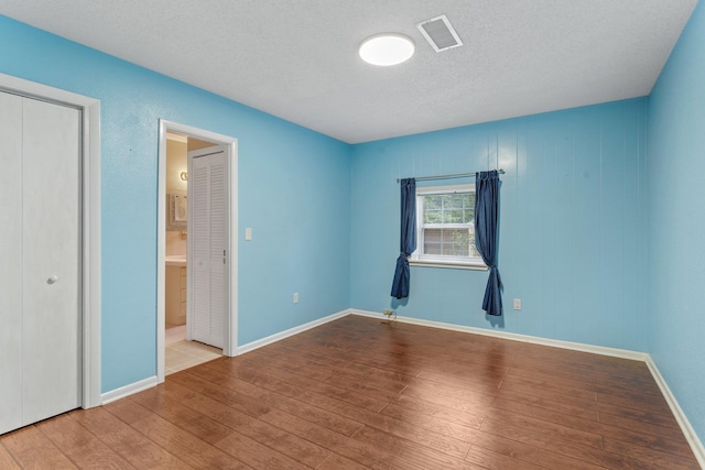 unfurnished room featuring a textured ceiling and light wood-type flooring