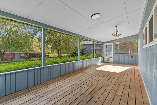 unfurnished sunroom featuring lofted ceiling and an inviting chandelier