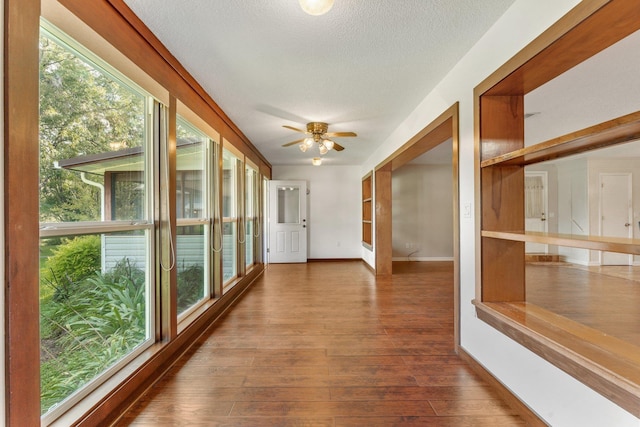 hallway featuring wood-type flooring and a textured ceiling