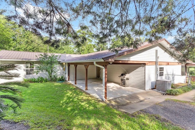 view of side of home featuring a carport, a yard, and central AC