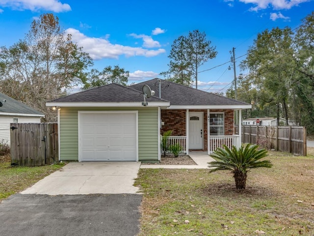 ranch-style house with a front yard, a garage, and covered porch