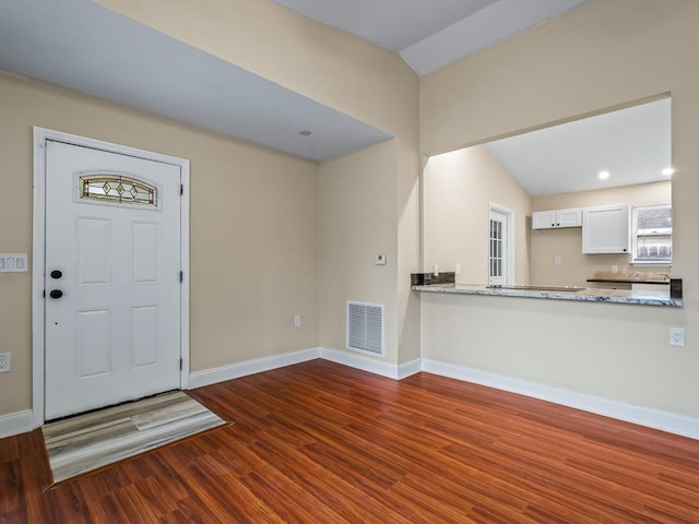 entrance foyer featuring dark hardwood / wood-style flooring and lofted ceiling