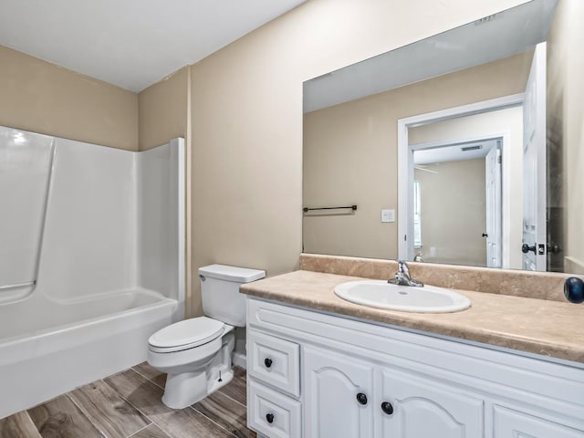 full bathroom with vanity, toilet, wood-type flooring, and washtub / shower combination