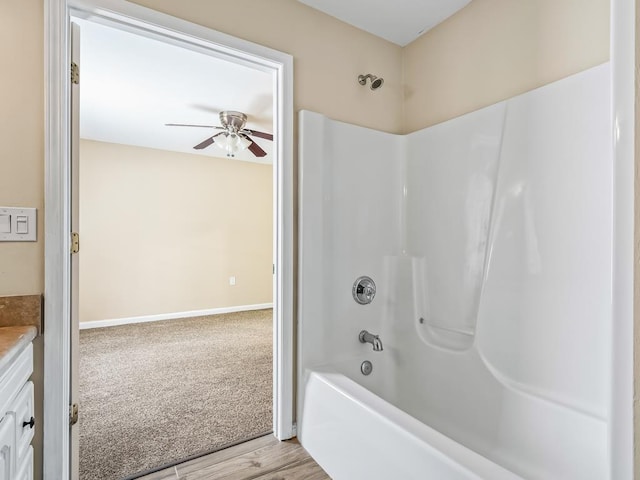 bathroom with ceiling fan, vanity, tub / shower combination, and hardwood / wood-style flooring