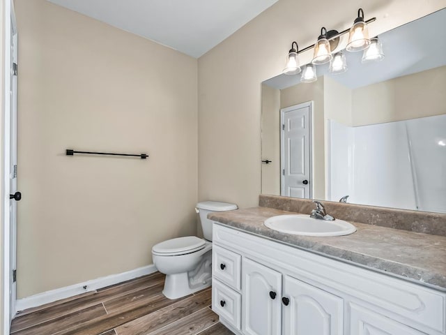 bathroom with a shower, vanity, hardwood / wood-style flooring, and toilet