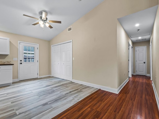 interior space featuring ceiling fan, light wood-type flooring, and vaulted ceiling