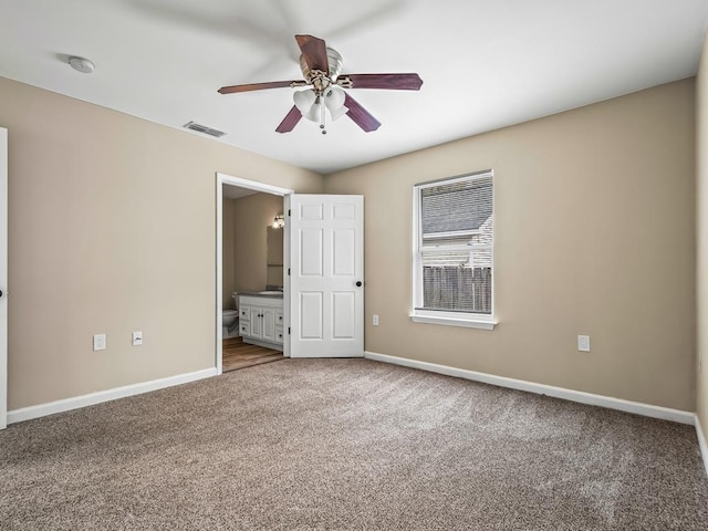 unfurnished bedroom with carpet, ceiling fan, and connected bathroom