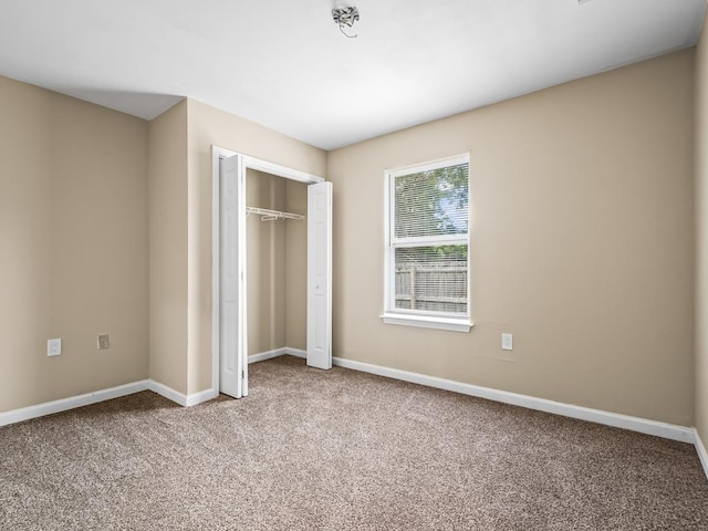 unfurnished bedroom with carpet flooring and a closet