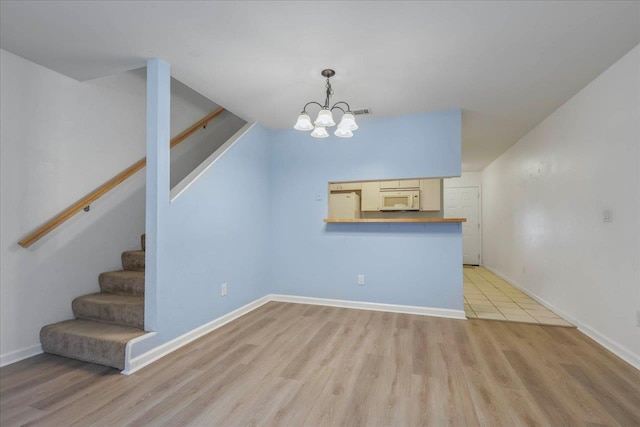 787 E Timberwood Cir, Tallahassee, FL 32304 - unfurnished dining area with stairs, light wood finished floors, a chandelier, and baseboards