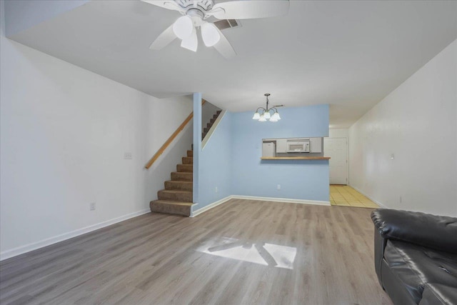 787 E Timberwood Cir, Tallahassee, FL 32304 - unfurnished living room featuring wood finished floors, a chandelier, stairway, and baseboards