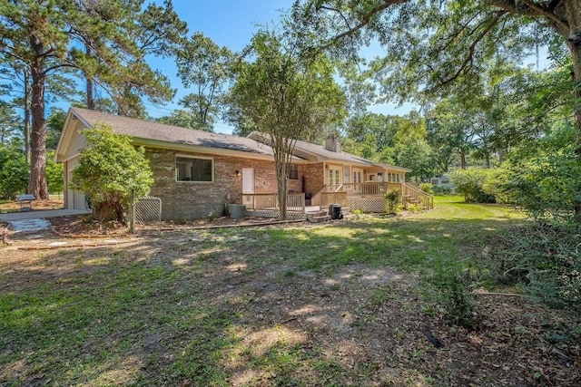 9025 Buck Lake Rd, Tallahassee, FL 32317 - back of property featuring a chimney, brick siding, a garage, and a lawn