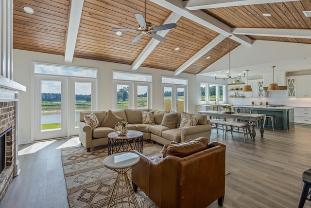 living area with wood ceiling, wood finished floors, beamed ceiling, french doors, and a brick fireplace