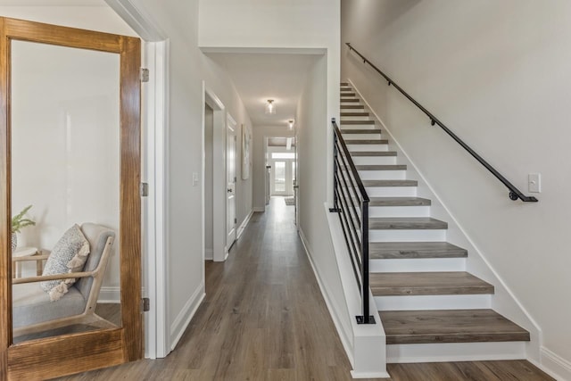 staircase with wood finished floors and baseboards