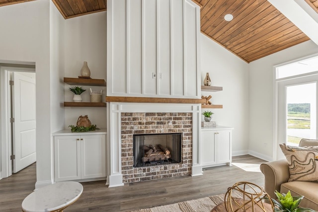 living area featuring wooden ceiling, wood finished floors, and a brick fireplace