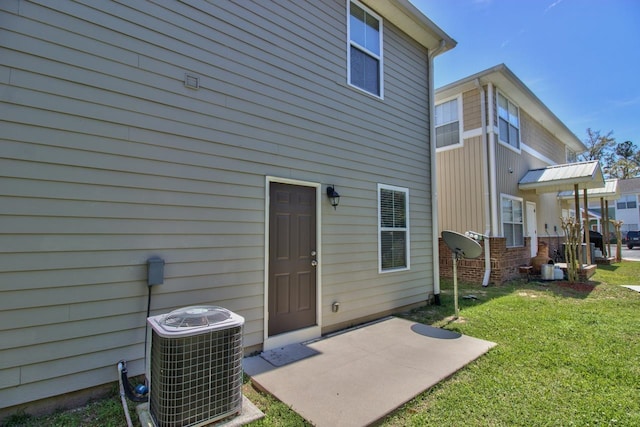 rear view of property with central AC and a lawn