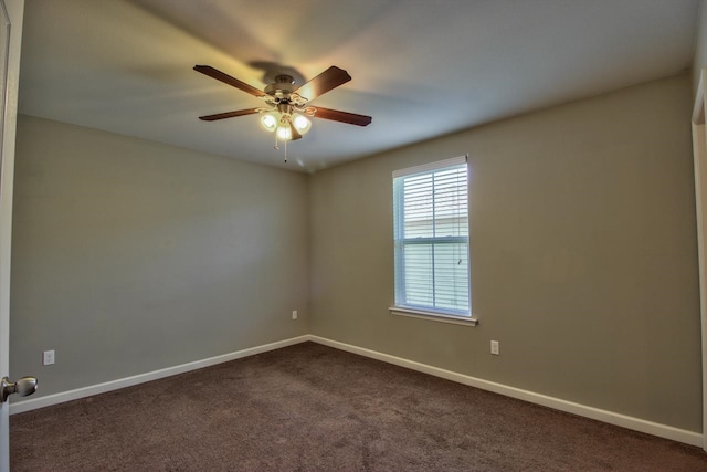 empty room with ceiling fan and dark carpet