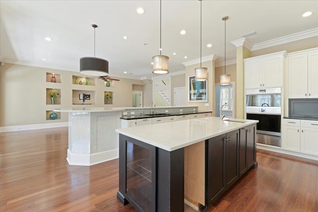 3621 Moody Trl, Tallahassee, FL 32309 - kitchen featuring a sink, beverage cooler, ornamental molding, a kitchen island with sink, and dark wood-style floors