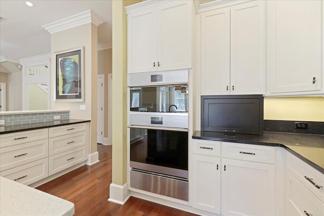 3621 Moody Trl, Tallahassee, FL 32309 - kitchen featuring a warming drawer, stainless steel double oven, dark wood-style floors, ornamental molding, and white cabinets