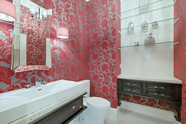 3621 Moody Trl, Tallahassee, FL 32309 - bathroom featuring wallpapered walls, toilet, vanity, and baseboards