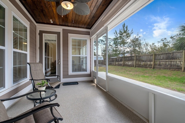 unfurnished sunroom featuring ceiling fan, plenty of natural light, and wood ceiling